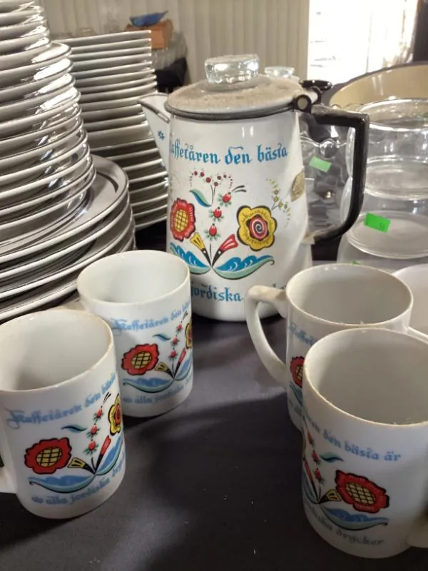 Colorful folk-art coffee mugs and a matching pitcher
