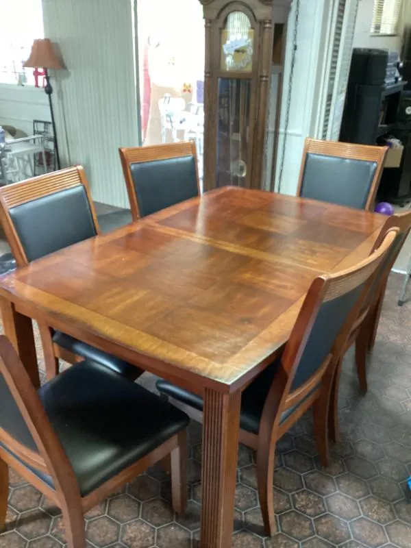 Wood dining table with black-cushioned chairs