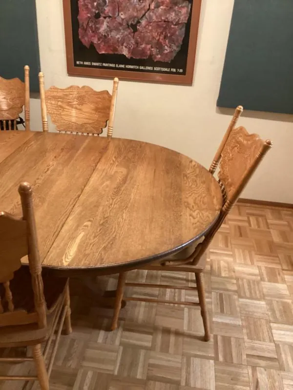 Round oak dining table with pressed-back chairs