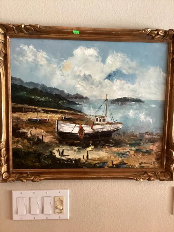 Framed painting of a boat on the shore