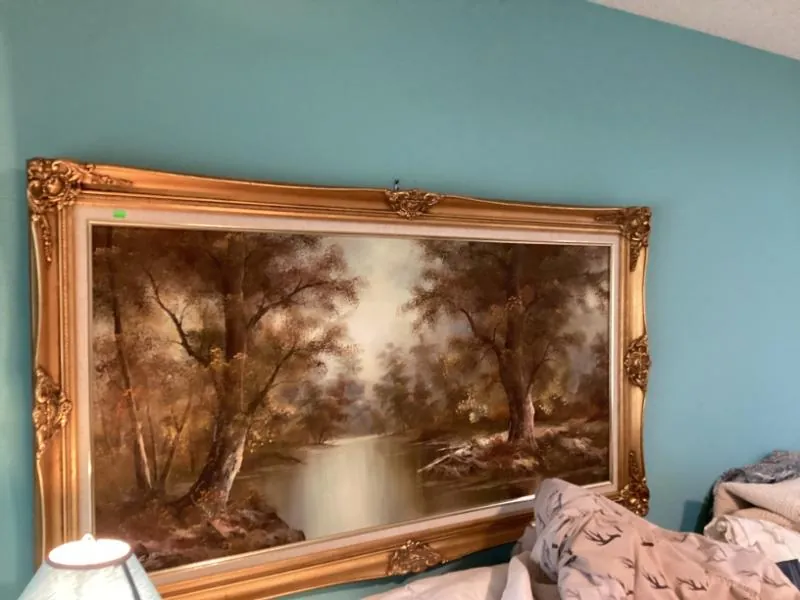 Painting of a forest in an ornate gold frame
