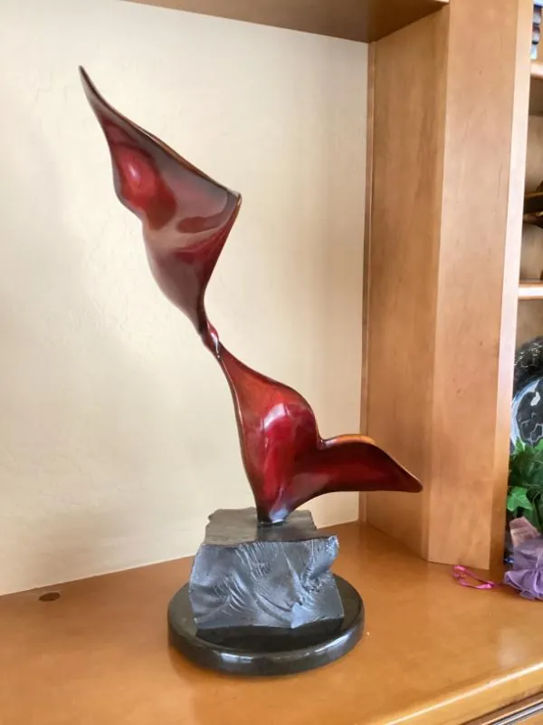 Red and clear glass art sculpture on a stone base