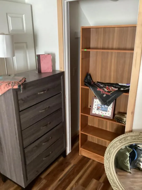 Gray chest of drawers beside a wood bookshelf