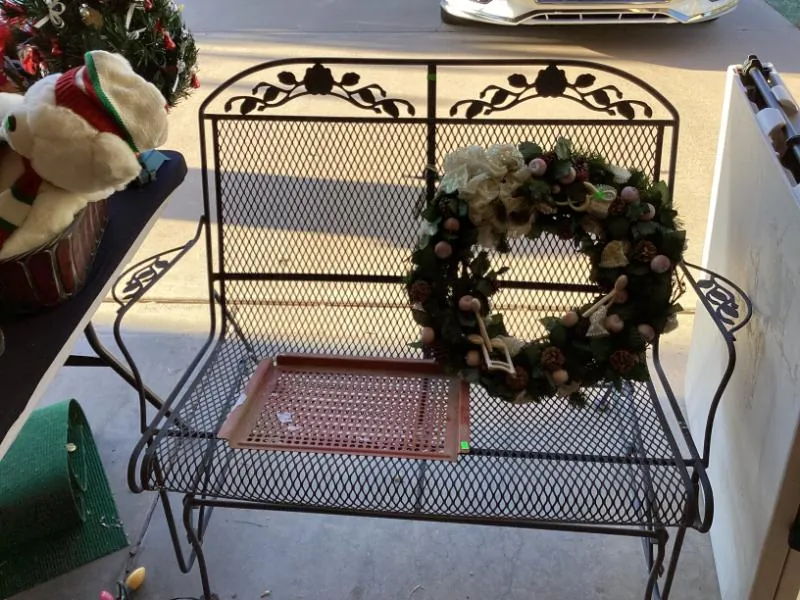Black metal bench with a Christmas wreath