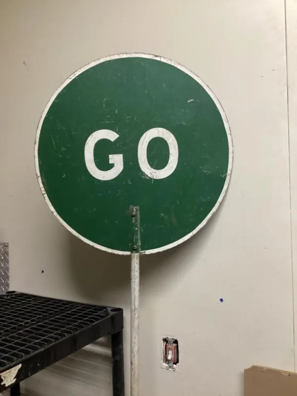Round green GO sign on a pole