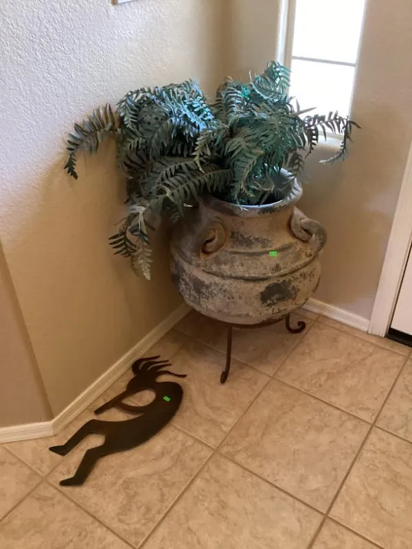 Potted fern with a metal Kokopelli-style figure