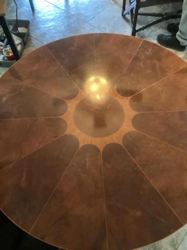 Round wood table with a sunburst inlay top