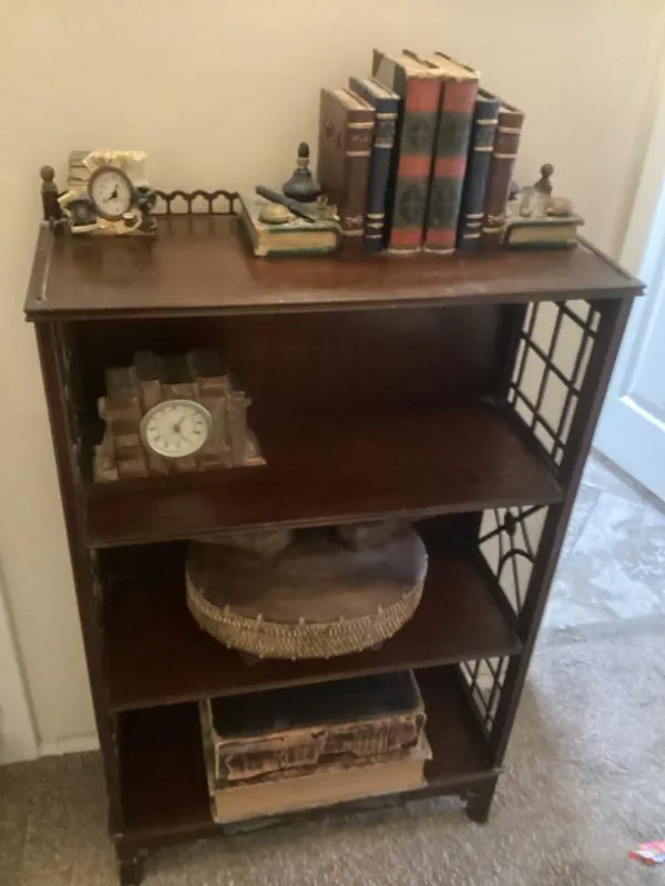 Bookshelf with bookends, old books and a clock