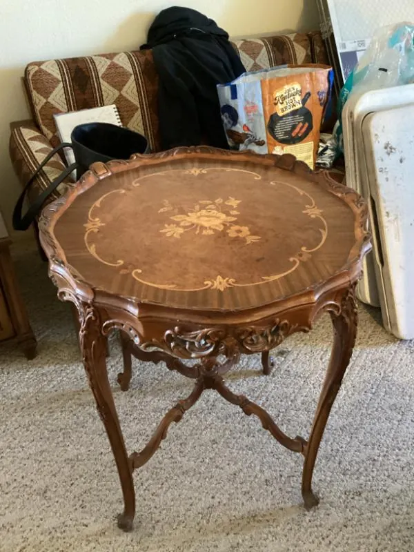 Round wood table with a floral inlay and carved legs