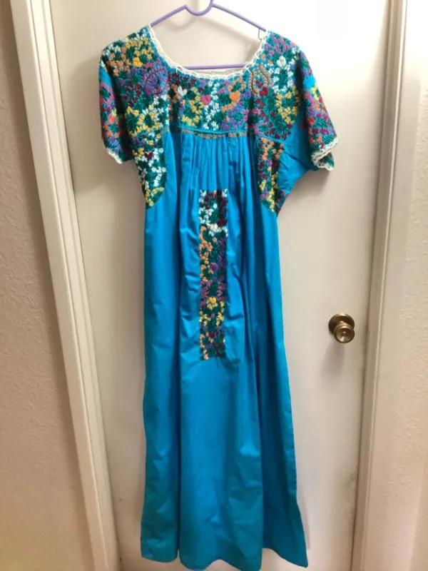 Blue embroidered dress on a hanger