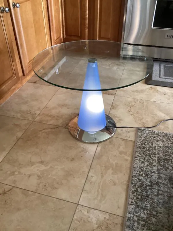 Glass-top side table with a glowing blue cone base