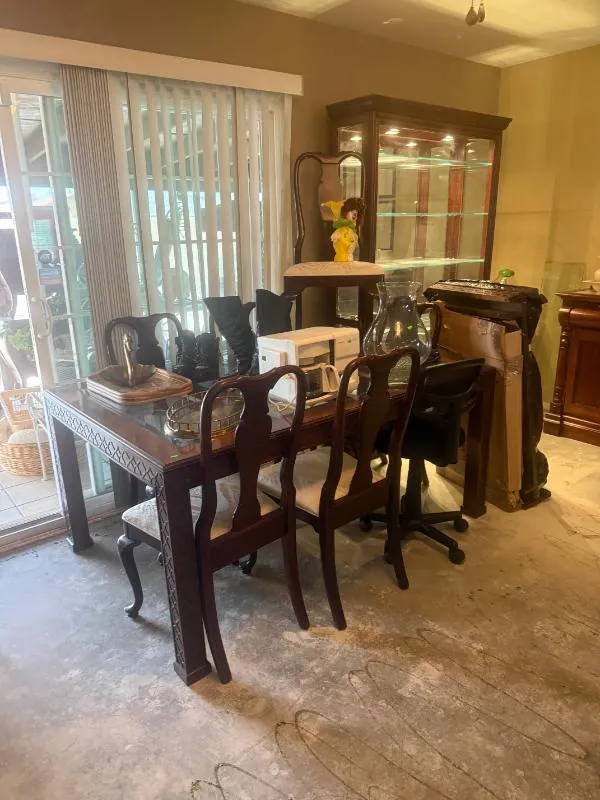 Dining table with chairs in front of a lighted cabinet