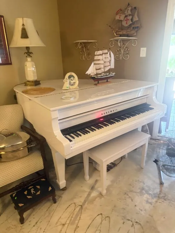 White piano with a bench