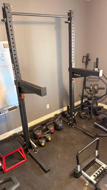 Rogue squat rack with kettlebells on a gym floor