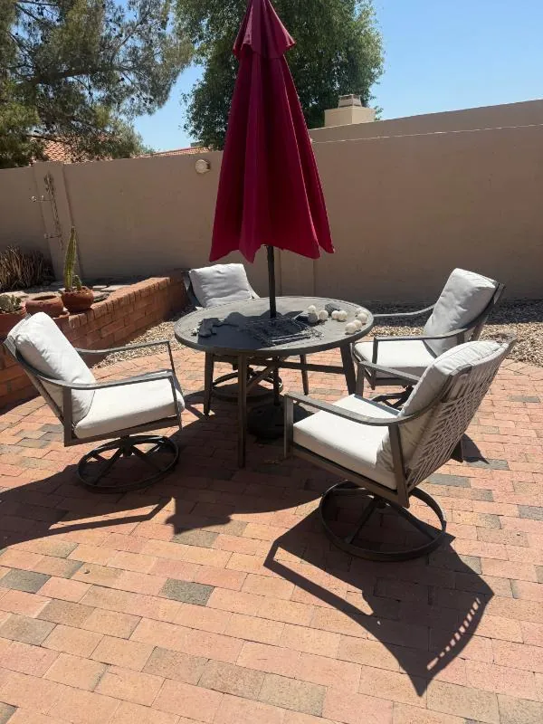 Patio table and chairs under a red umbrella