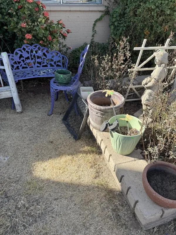 Blue metal garden bench beside planters