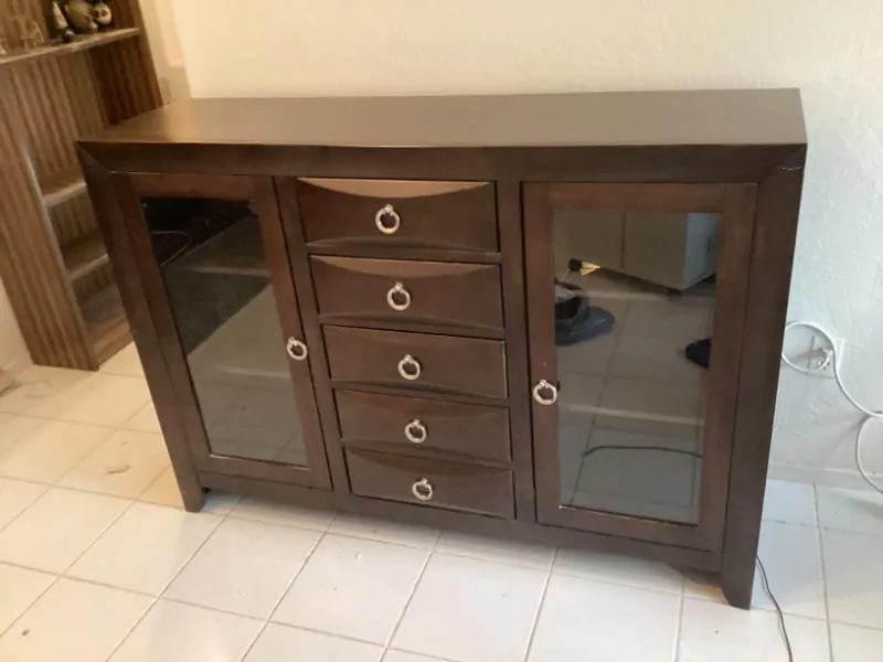 Dark wood sideboard with glass doors and drawers