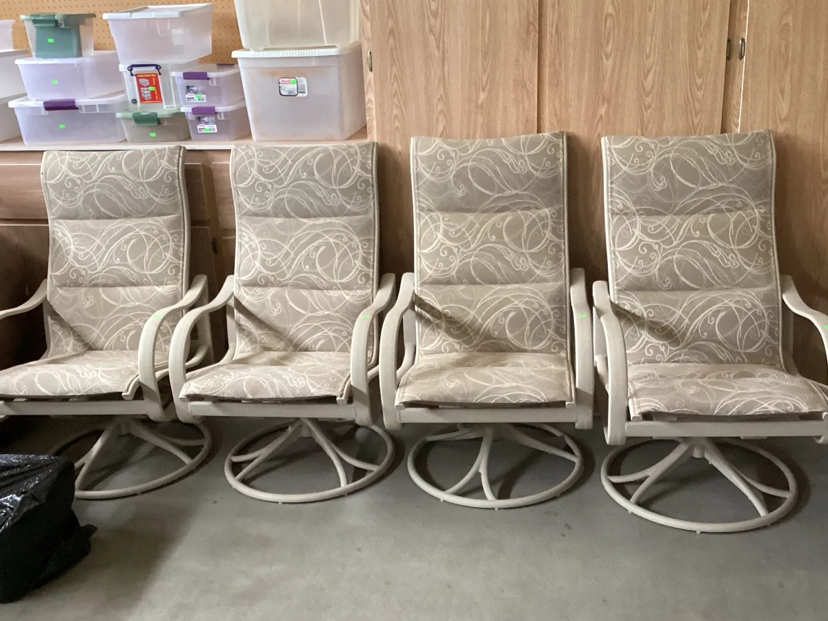 Four cushioned patio swivel chairs