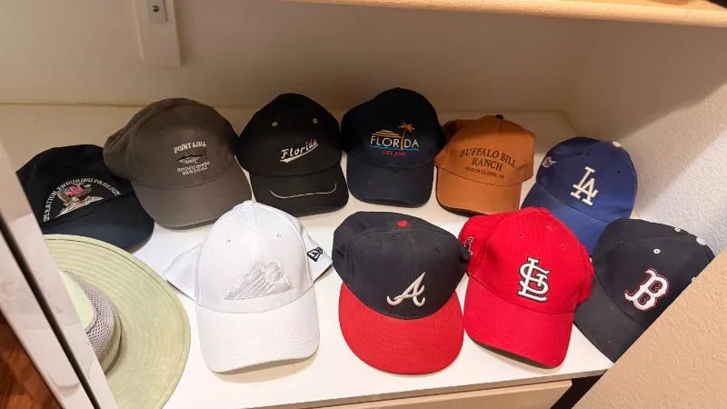 Baseball caps on a closet shelf