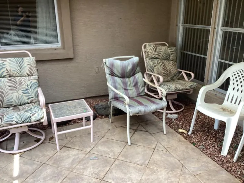 Patio chairs and a swivel rocker on a covered patio