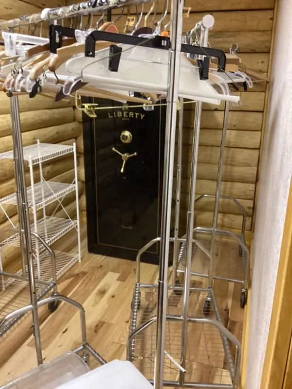 Black safe behind metal clothing racks
