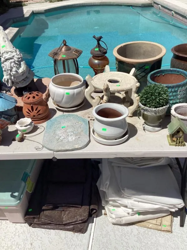 Table of clay flower pots and planters beside a pool