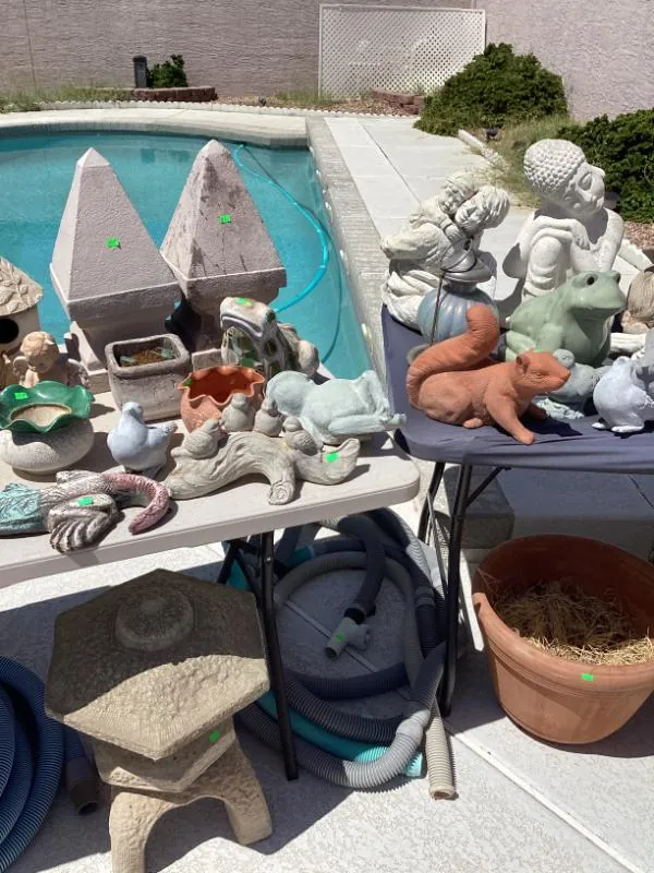 Table of concrete garden statues beside a pool