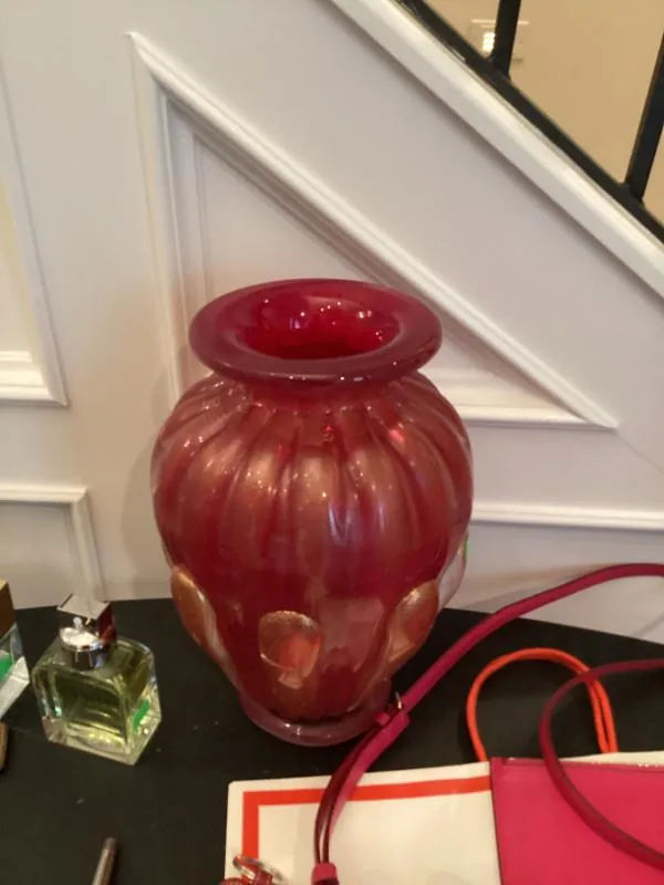 Large red glass vase on a table