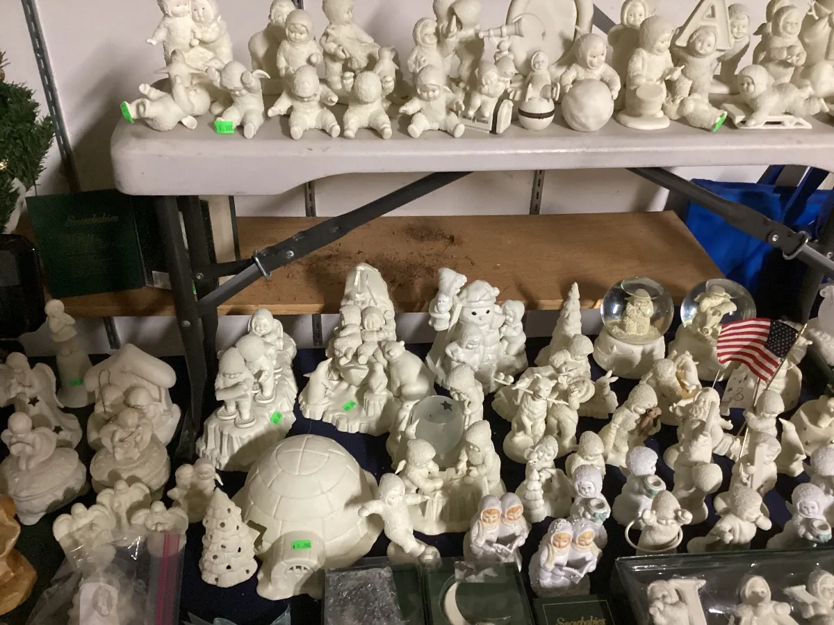 Tables crowded with small white porcelain snow baby figurines